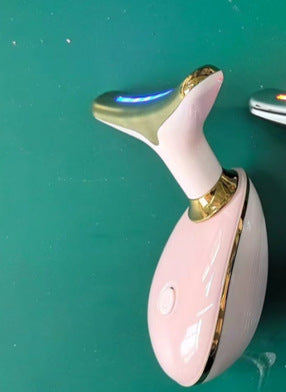 Pink and gold electronic device on a green surface